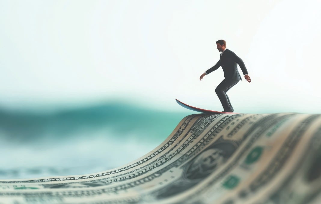 Businessman miniature surfing on a dollar bill wave