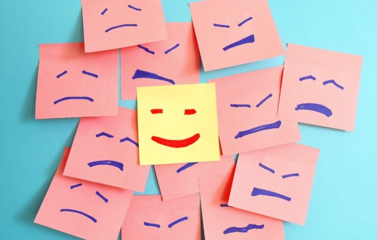 sticker with a smiling face drawn among sad faces