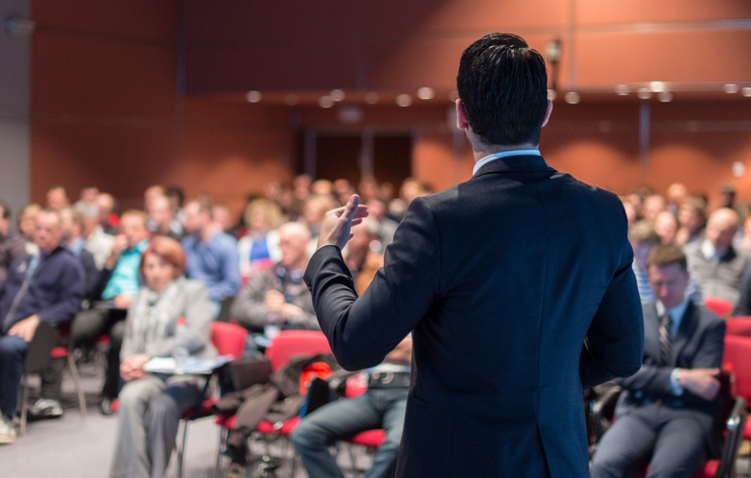 Speaker giving a talk at corporate business conference.
