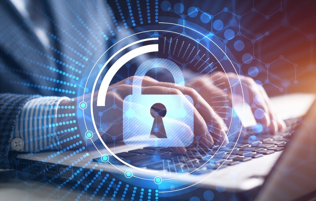 Image of lock overlayed man typing on laptop